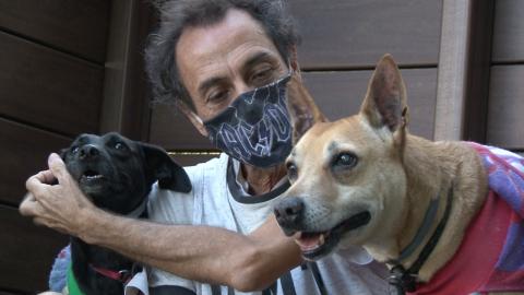 homem está junto a dois cães. #paratodosverem