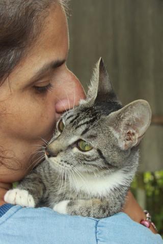 mulher beija gatinha que está aconchegada em seu ombro. #paratodosverem