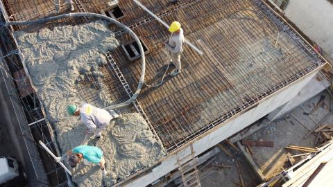 vista aérea de concretagem de solo com armação de ferro. Homens estão espalhando o concreto. #paratodosverem