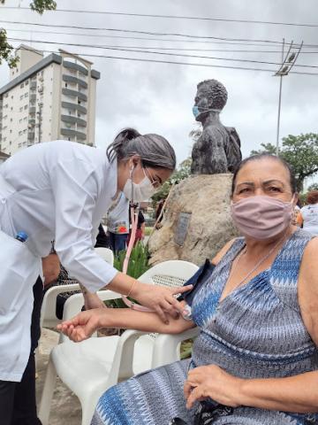 Mulher tem pressão aferida por profissional de saúde. #pracegover