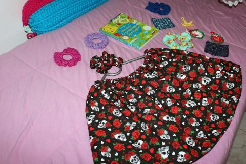 shorts de tecido e pequenas peças de crochê sobre uma cama em exposição. #paratodosverem