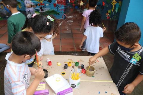Crianças usam pinceis em atividade #paratodosverem