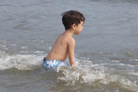 criança brincando no mar #paratodosverem