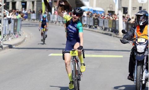 Ciclista pedalando e erguendo o braço em comemoração #paratodosverem