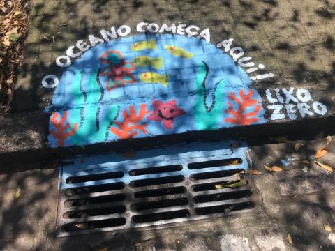 bueiro com pintura de oceano e mensagem: o oceano começa aqui. #paratodosverem 
