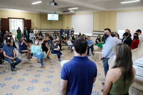 Sala com autoridades e pessoas sentadas #paratodosverem