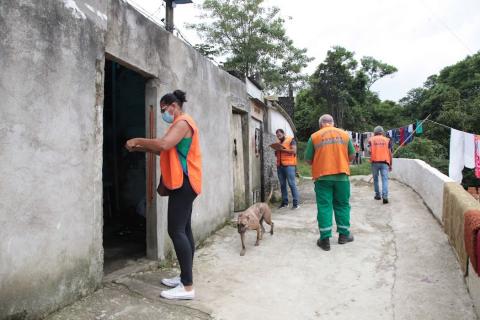 trabalhadores da defesa civil em frente a residencias no morro #paratodosverem