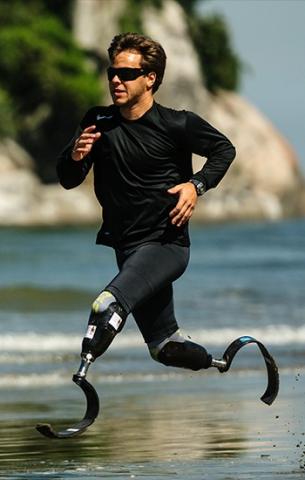 Atleta bi-amputado corre na beira do mar. #paratodosverem