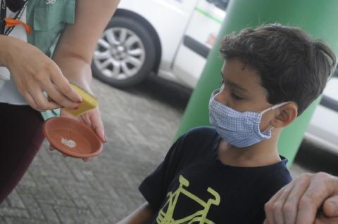 criança observa agente limpando recipiente #paratodosverem