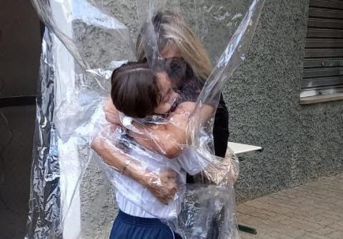 mulher e criança se abraçam com a cortina #paratodosverem
