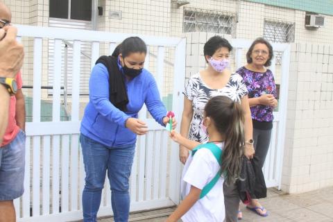 menina entrega flor para mulher na rua. #paratodosverem