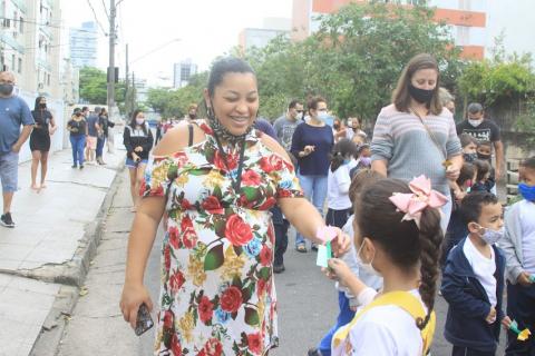 menina entrega flor para mulher na rua. #paratodosverem