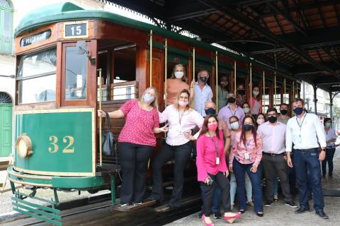 servidores posam para foto diante do bonde. #paratodosverem