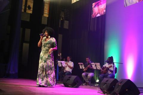 Claudia França canta no palco. #paratodosverem