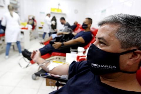 Várias pessoas sentadas doando sangue. #paratodosverem