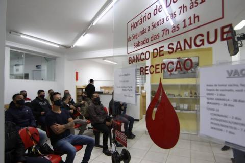 Várias pessoas sentadas aguardando para fazer a doação. #paratodosverem