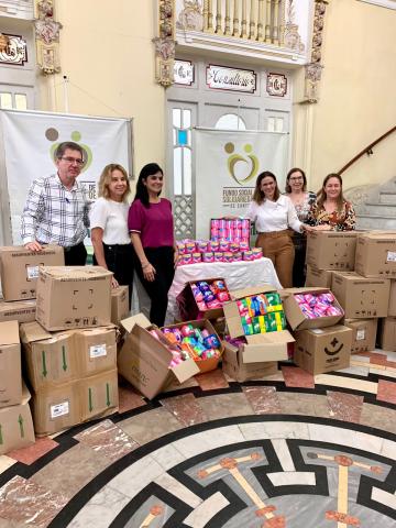 seis pessoas reunidas em torno de caixa com absorventes. #paratodosverem