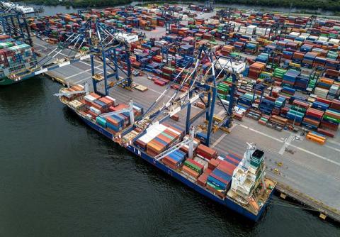 terminal portuário com navios encostados no cais e portâineres em terra. #paratodosverem