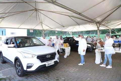 movimento de veículos sob tendas em drive-thru. #paratodosverem