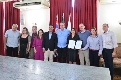 pessoas posando atrás de mesa #paratodosverem