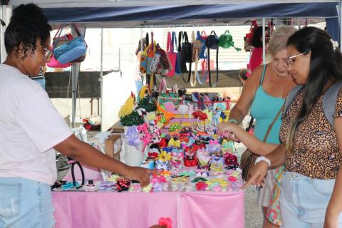 mulheres olham enfeites a venda #paratodosverem