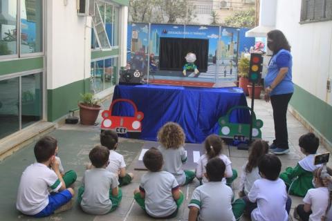 Crianças observam teatro de fantoche. #paratodosverem