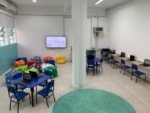 Estudioteca com mesas, cadeiras e computadores #paratodosverem