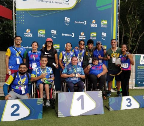 Atletas posam para foto com medalhas no pódio #paratodosverem