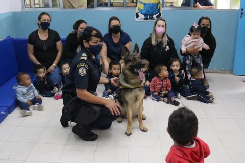 Guarda ao lado de cachorro, adultos e crianças #paratodosverem