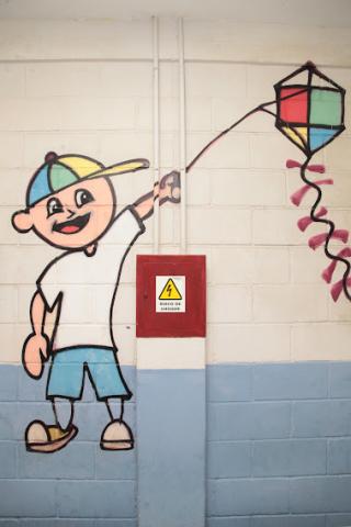 caixa de luz sinalizada ao lado de desenho pintado em parede. #paratodosverem
