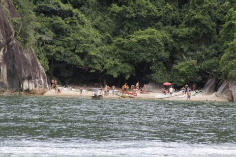 vista da praia do Cheira Limão, em Guarujá, com a pria e vasta vegetação ao fundo.#paratodosverem