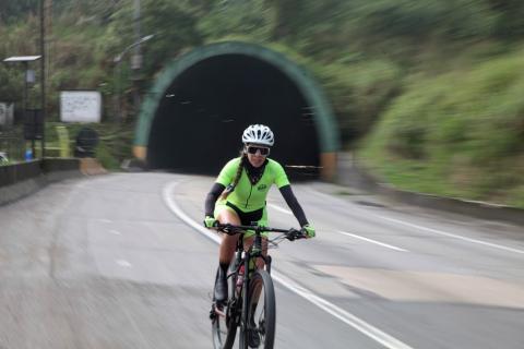 ciclista em trecho de rodovia, saindo de túnel. #paratodosverem