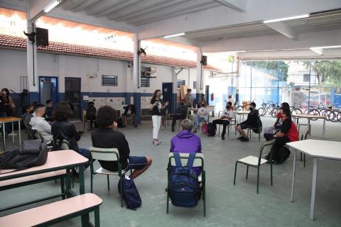 Rhayssa está no centro de uma roda de alunos. #paratodosverem