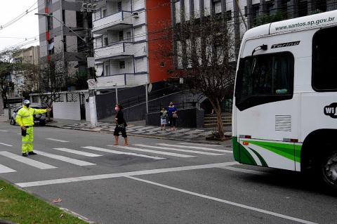 Agente da CET para ônibus para pedestre passar. #paratodosverem