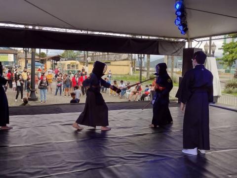 Crianças realizam apresentação de arte marcial em palco montado no Valongo. #pracegover