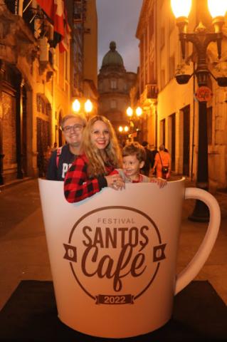 Família, com homem, mulher e criança, posa para foto na xícara gigante instalada na Rua XV. #pratodoverem 