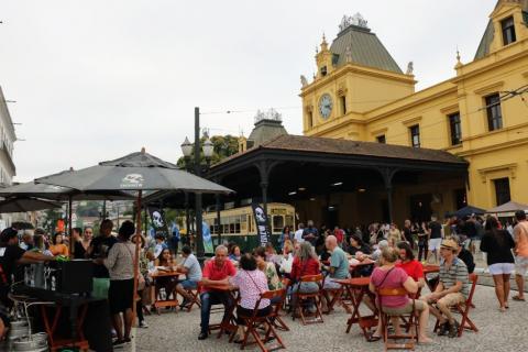 Público se alimenta em mesas colocadas em frente ao Museu Pelé, no Valongo. #pratodosverem