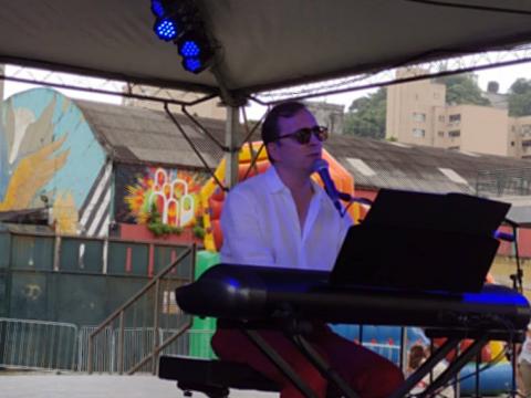 O cantor francês Aymeric Frerejean canta e toca teclado no palco do evento. #pracegover