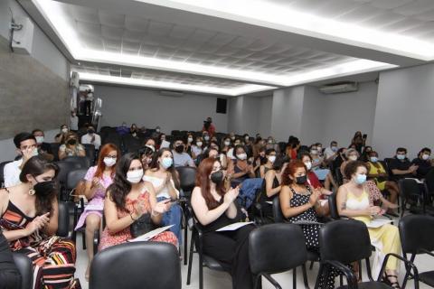 auditório com diversas pessoas sentadas. A maioria bate palmas. #paratodosverem