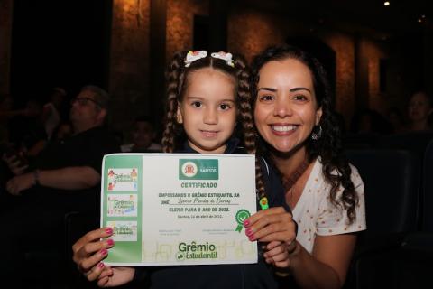 meninas segura certificado do grêmio ao lado de uma mulher. #paratodosverem