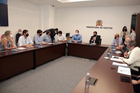 Várias pessoas sentadas na mesa durante reunião. #paratodosverem