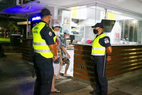 Guardas municipais conversam com homem em quiosque sem movimento. #paratodosverem