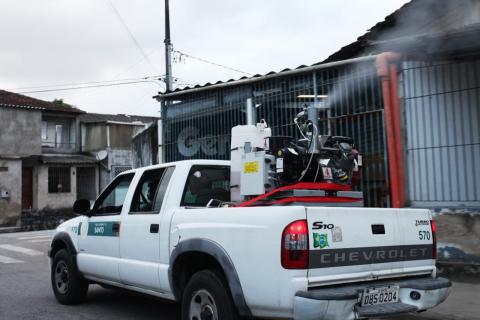 Maquinário em caçamba de veículo lança fumaça em casas. #Paratodosverem