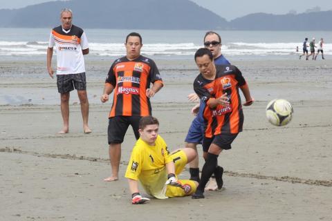 lance de jogo. Um menino está no chão. Outros três estão em pé. A bola está no ar. #paratodosverem