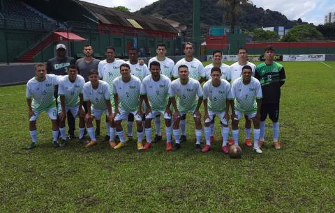 Time de futebol masculino posa para foto no gramado #paratodosverem