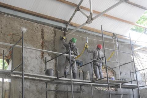 Trabalhadores realizando obra em parede #paratodosverem