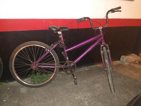 bicicleta roxa encostada em parede. #paratodosverem