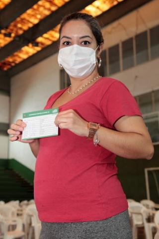 grávida posa com comprovante de vacina. #paratodosverem