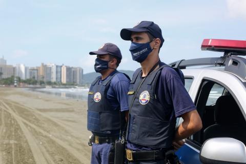 Dois quardas municipais e viatura em primeiro plano. Eles estão na faixa de areia. #Paratodosverem