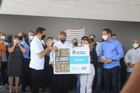 Presidente do Fundo Social do Estado, ao lado de governador, prefeito e vice-prefeita, exibe placa com inscrição de 2 mil cestas básicas. #pracegover